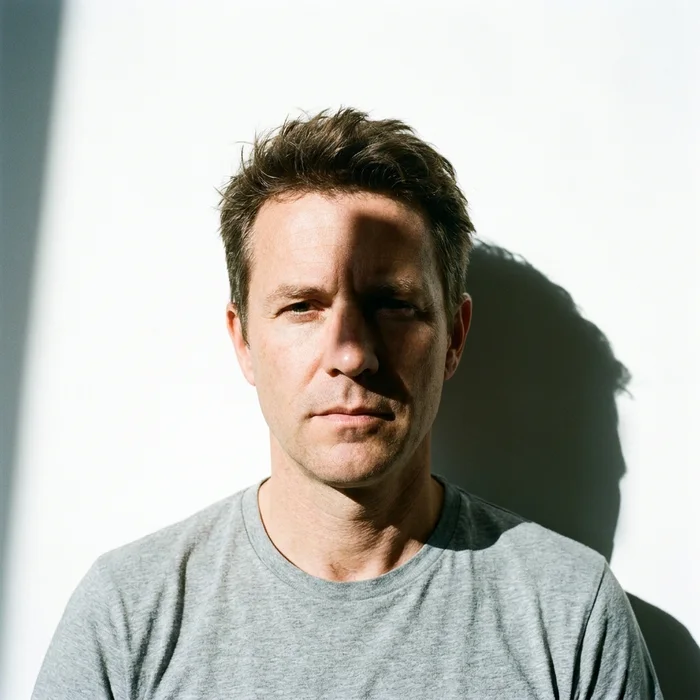 Rejected passport photo — refused — a hard shadow cast onto the wall behind the head